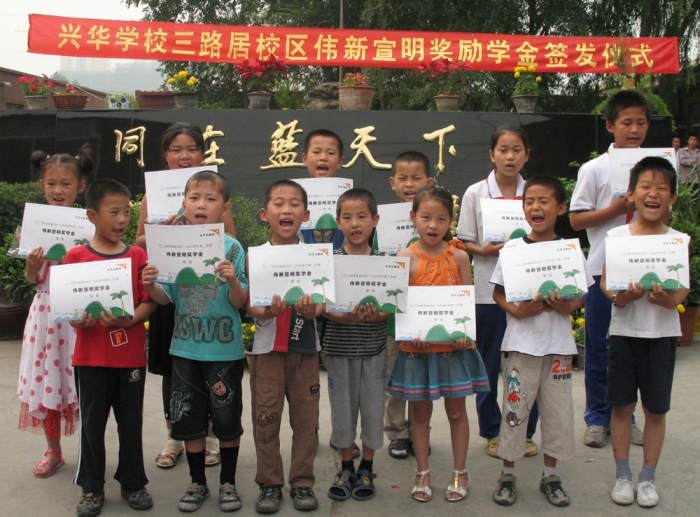 Students from Beijing Xinghua Primary School who received educational grants supported by HKS Education Fund happily took a group photo in front of the school gate.